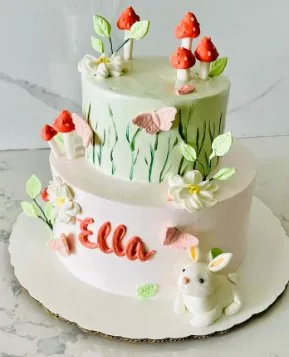 Bizcocho de dos pisos con tema de jardín, hongos y conejito en fondant para cumpleaños